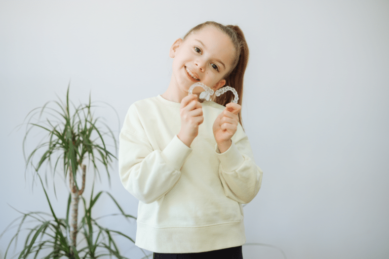 Child holding clear aligners during an orthodontic evaluation in Savannah, GA