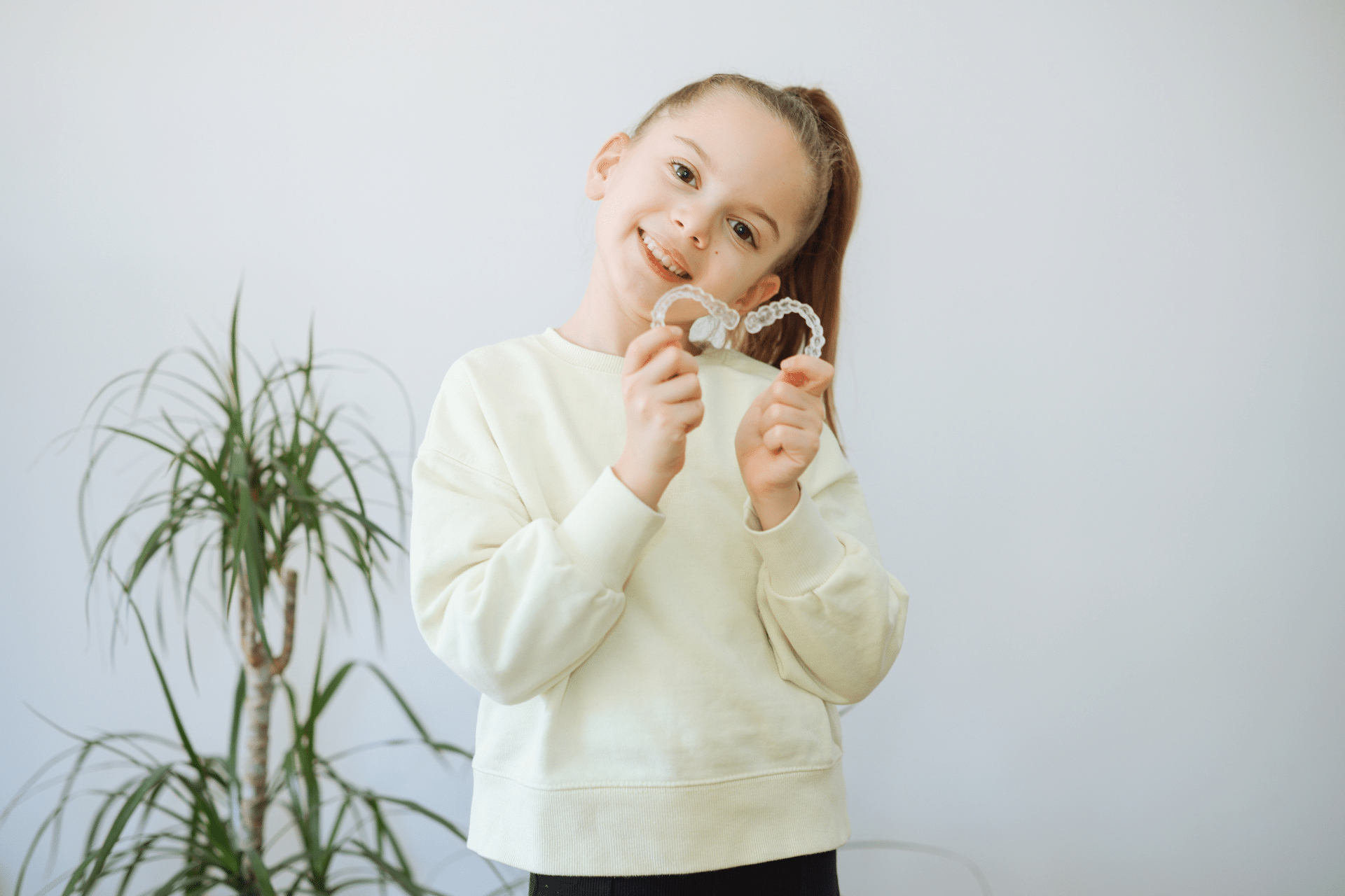 Child holding clear aligners during an orthodontic evaluation in Savannah, GA