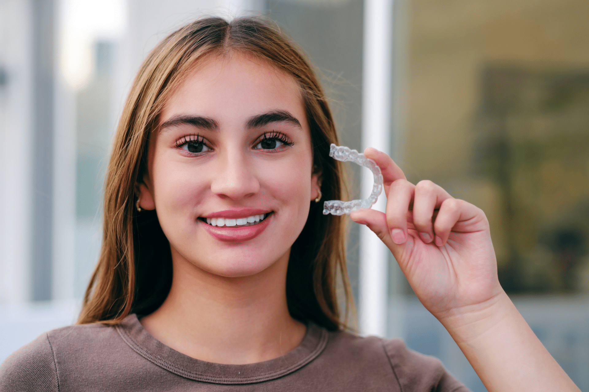 Teen holding clear aligners for Invisalign treatment in Richmond Hill, GA